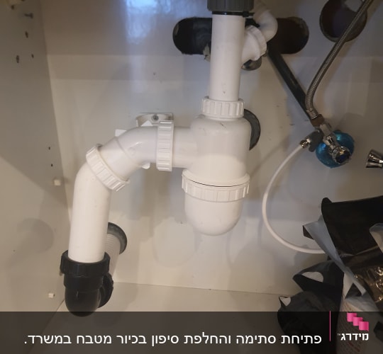 צנרת פלסטיק לבנה מתחת לכיור עם מחברים